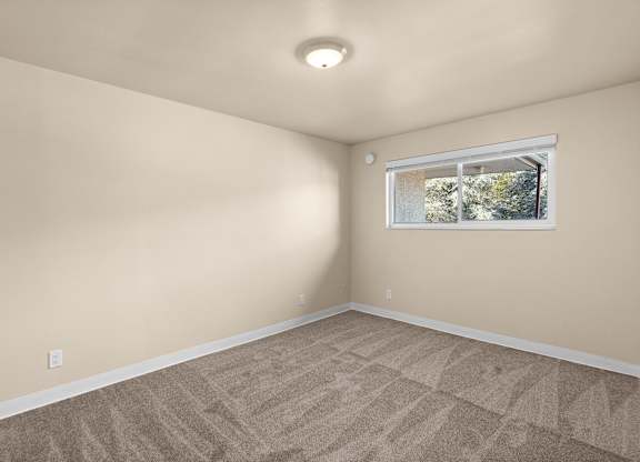 an empty room with carpet and a window