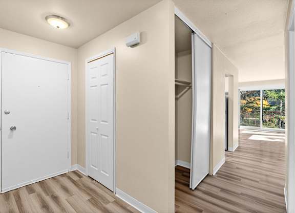 an empty room with doors to a closet and a window
