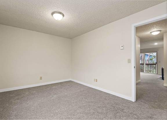 A room with a carpeted floor and a doorway leading to another room. at Brookstone, SeaTac