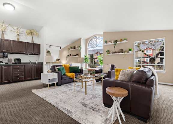 A living room with a brown couch and a grey rug.