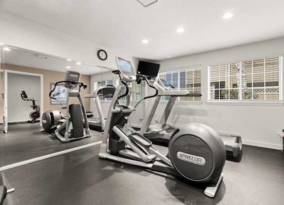 A gym with a treadmill, exercise bike, and other equipment.