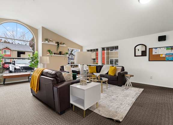 A living room with a brown couch and a white coffee table.