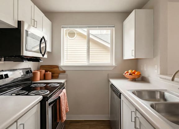 A kitchen with a black stove top oven and white cabinets.