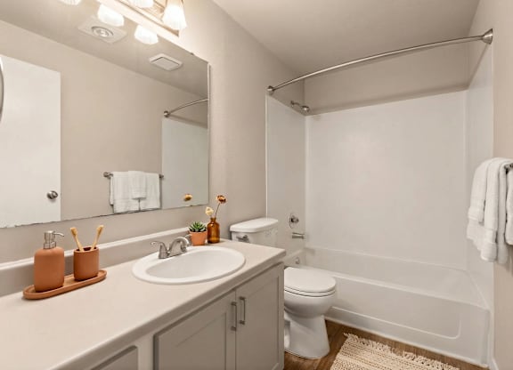 A bathroom with a white toilet, sink, and bathtub.