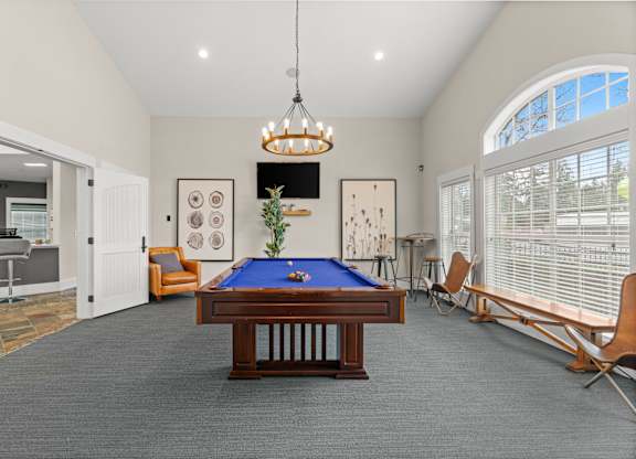 A room with a pool table and a chair.