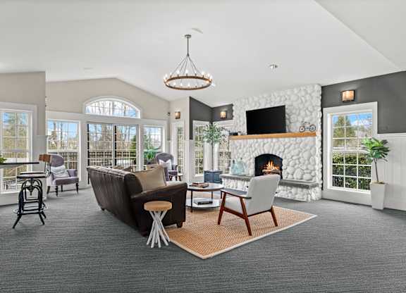 A modern living room with a fireplace and a large window.