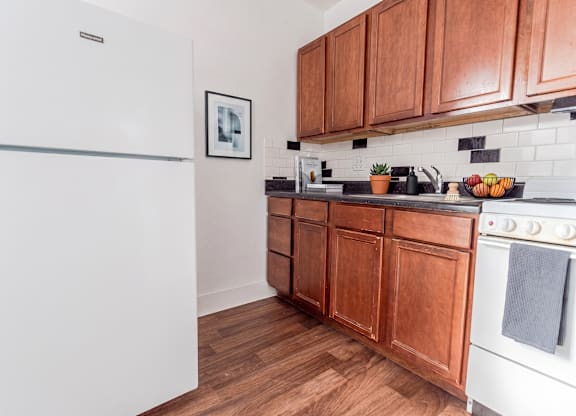 A kitchen with wooden cabinets and a white refrigerator.