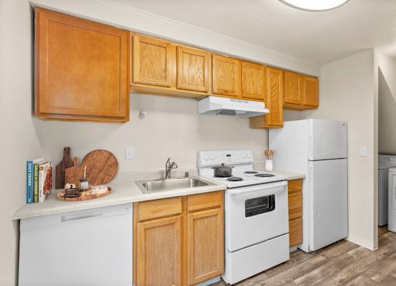 A kitchen with wooden cabinets and white appliances.