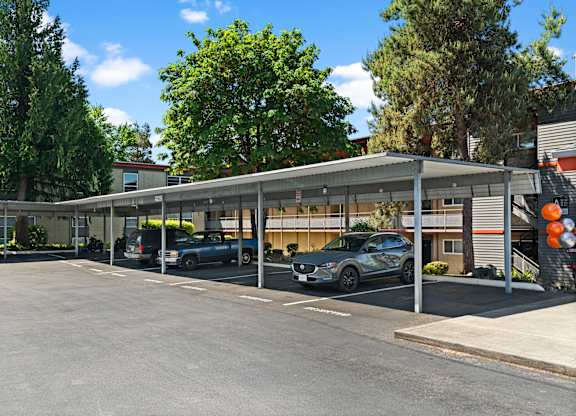A parking lot with cars and a building in the background.