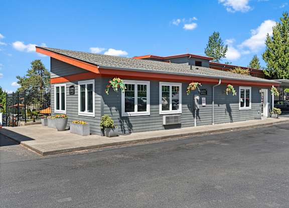 A grey building with a red roof and white trim.
