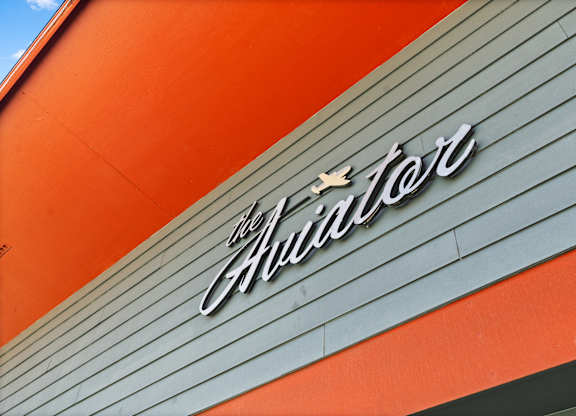 A sign that says "The Hustler" is on a building.