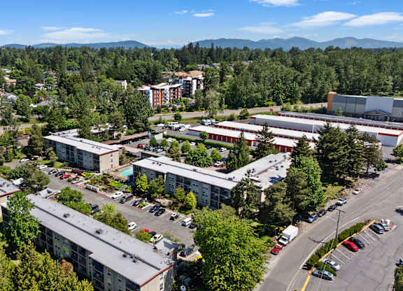 A large building complex with a parking lot in front.