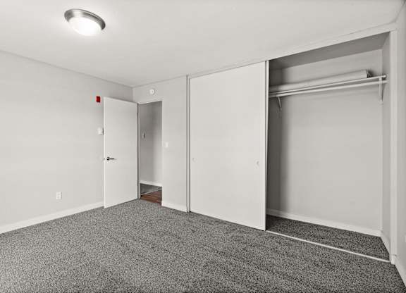 A room with a grey carpet and a white door.