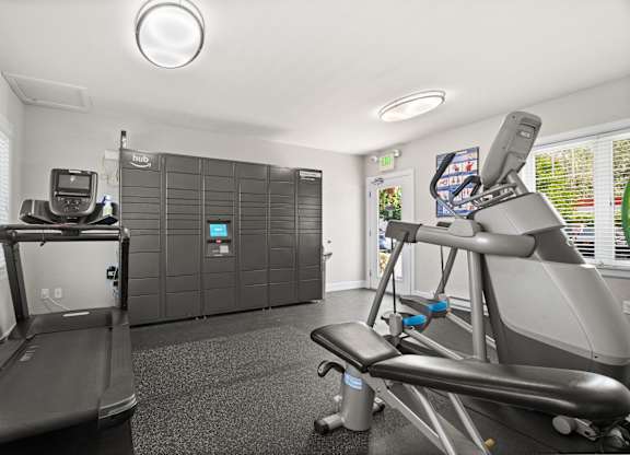 A treadmill and a stationary exercise bike are in a room with a window.