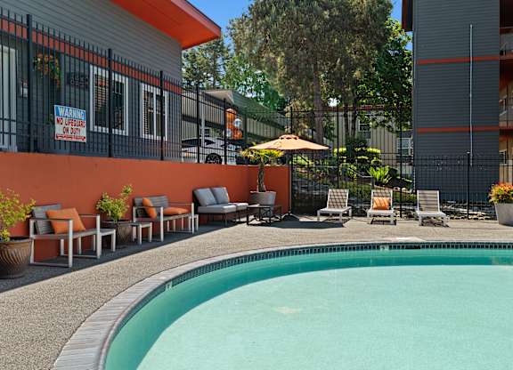 A pool area with chairs and a sign that says "No Pets Allowed".