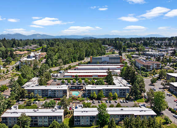 A large building complex with a parking lot in front of it.