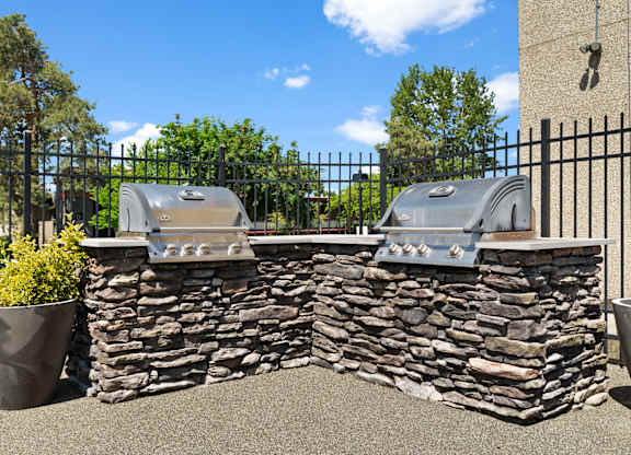 Two grills are built into a stone wall.