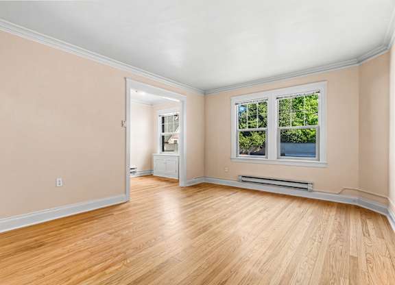 A room with a window and a radiator on the wall.