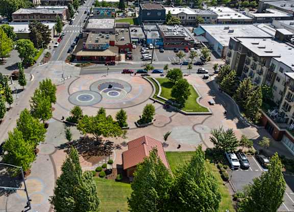 A city square with a fountain in the middle of it.