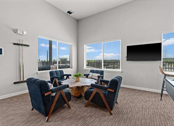A room with a table and chairs and a television.