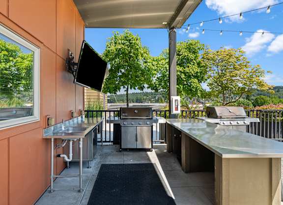 A patio with a television and a grill.