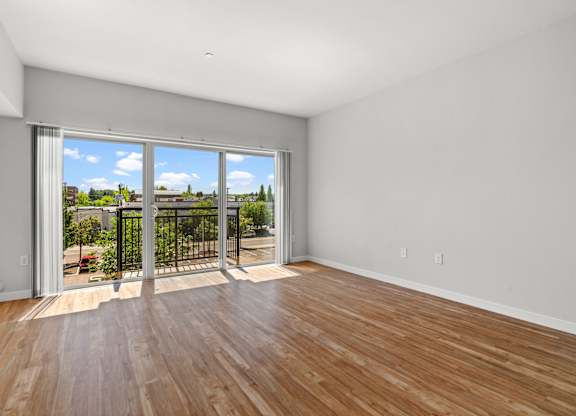 A room with a sliding glass door leading to a balcony.