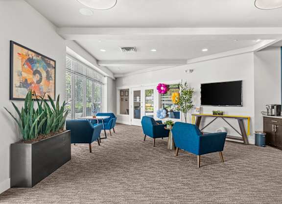 A modern living room with blue chairs and a television.