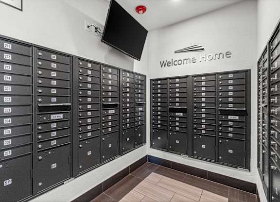 A wall of mailboxes with a sign that says Welcome Home.