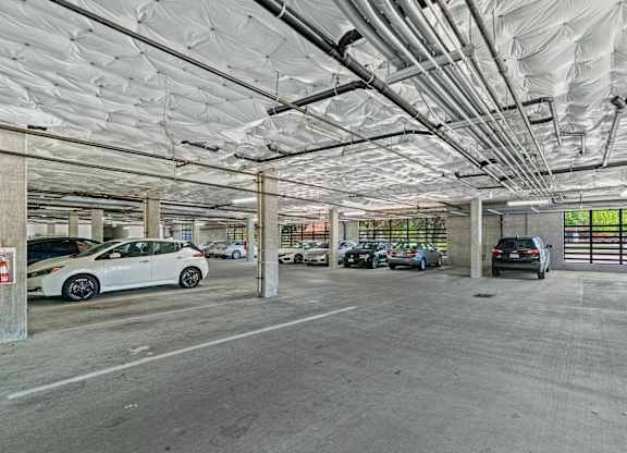A parking garage with multiple cars parked.