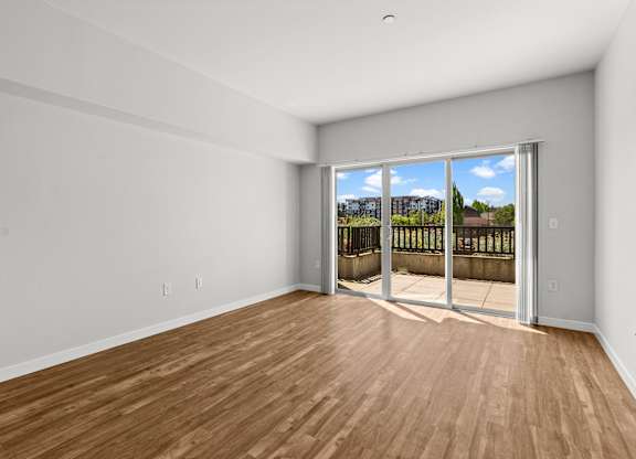 A room with a sliding glass door leading to a balcony.