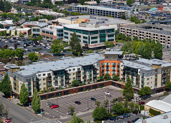 A parking lot is in the foreground of a city scene.