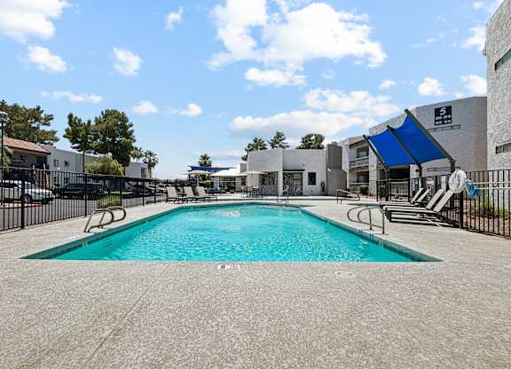 A large swimming pool surrounded by a black fence.