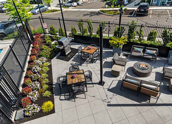A patio with a fire pit and seating area.