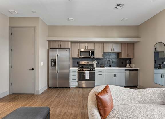 A modern kitchen with a refrigerator, oven, and microwave.