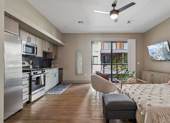 A modern kitchen with a refrigerator, stove, and microwave.