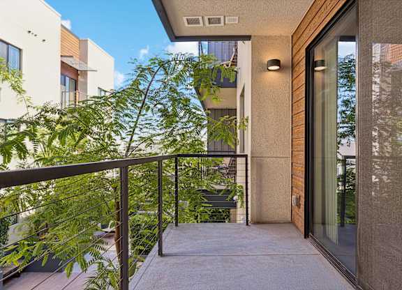 A balcony with a metal railing and a glass door.