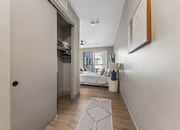 A hallway with a bedroom at the end.