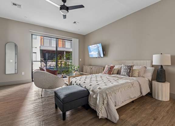 A bedroom with a large bed and a ceiling fan.