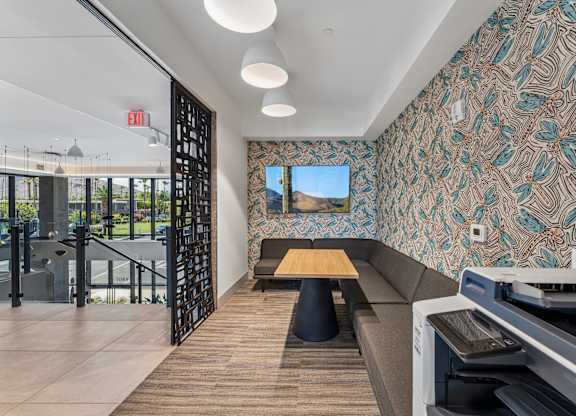 A room with a patterned wallpaper and a long bench.