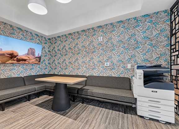 A room with a patterned wallpaper and a desert scene on the wall.
