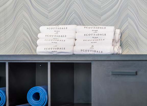 A shelf with yoga mats and towels with the word "Scottsdale" on them.
