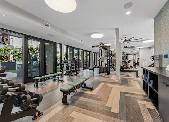 A gym with a variety of equipment and a bench.