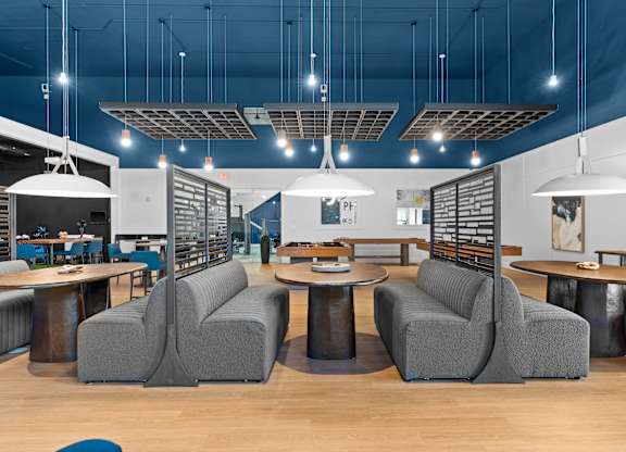 A modern furniture showroom with grey sofas and tables.