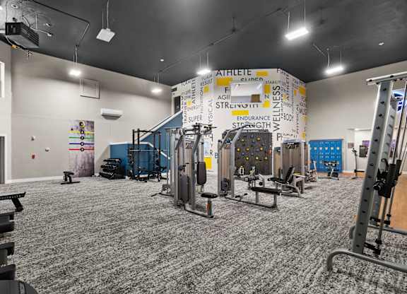 A gym with a variety of equipment including weights and machines.