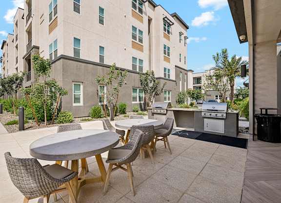 A patio with a table and chairs is in front of a building.