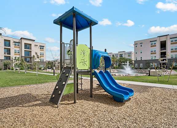 A playground with a blue slide and a green slide.