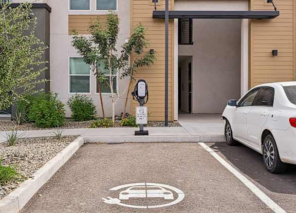 A white car is parked in a parking space with a sign that says "ECO" on it.