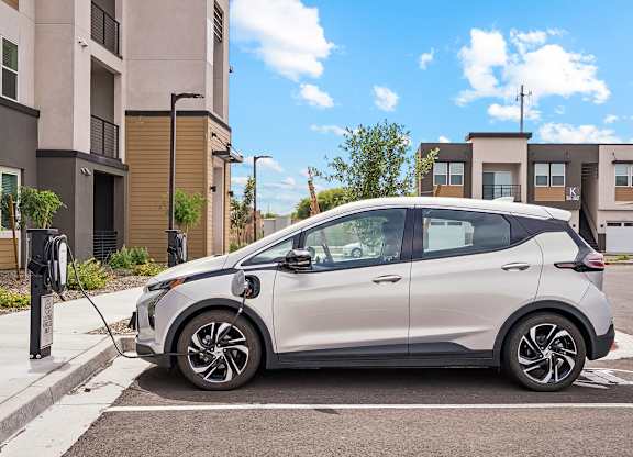 A silver car is parked and charging at an electric vehicle charging station.
