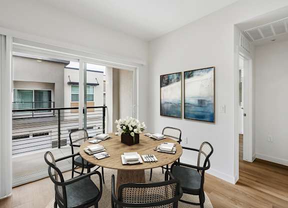 A dining room with a table set for six people.