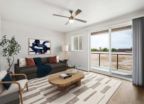 A living room with a brown couch, a wooden coffee table, and a ceiling fan.